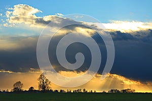 Big stormy cloud over the meadow at sunset