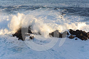 Big and strong waves breaking and crushing on the volcanic rocks on the Atlantic Ocean on coastline and seashore of Madeira Island