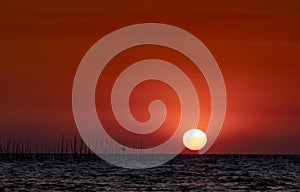 Big sun over the sea at sunset. Beautiful sunset sky and skyline. Red romantic sky for peaceful and tranquil background.