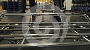 Big supermarket shopping cart in motion goes by group of people