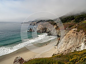 Big Sur California coast, bridge, beach, rocks, clouds, and surfing waves