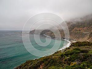 Big Sur California coast, bridge, beach, rocks, clouds, and surfing waves