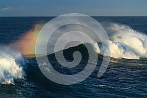 Big surf wave breaking, with rainbow colours