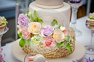 Big sweet multilevel wedding cake decorated with flowers. Concept of candy bar on party