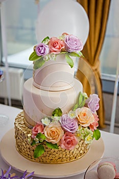 Big sweet multilevel wedding cake decorated with flowers. Concept of candy bar on party