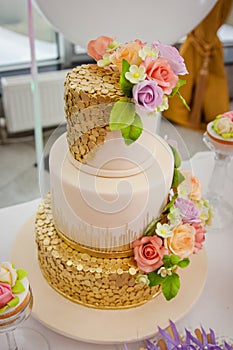 Big sweet multilevel wedding cake decorated with flowers. Concept of candy bar on party