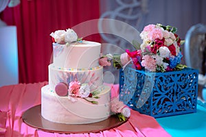 Big sweet multilevel wedding cake decorated with flowers. Concept of candy bar on party