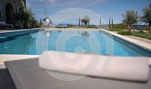 Big swimming pool on the yard with a luxury house in the background