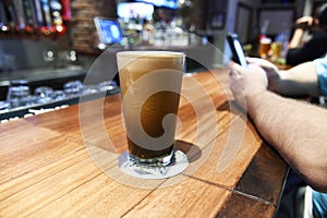 A big tall glass of frothy delicious beer at a bar photo
