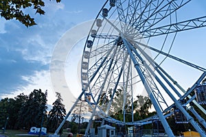 Big tall white Ferris wheel in front of a perfect blue sky