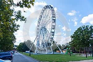 Big tall white Ferris wheel in front of a perfect blue sky