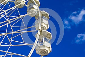A Big, Tall White Ferris Wheel in Front of a Perfect Blue Sky on the Ocean. Happy Summer Holidays