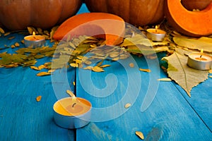 Big tasty autumn pumpkins with leaves on a blue background. Food concept.