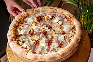 Big and tasty pizza with sun-dried tomatoes and feta cheese