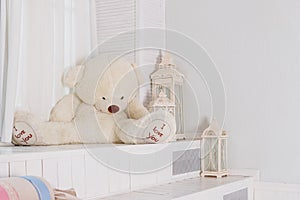 Big teddy bear near big white lantern,pillows in girly room. playroom interior.Beautiful child`s room in pastel tones