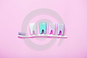 Big teeth and toothbrushon pink background. Minimal