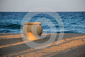 Big terra cotta pot on sandy beach