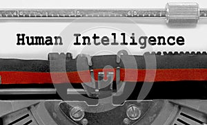 Big text human Intelligence by the old typewriter on white paper sheet