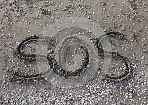 Big text SOS on the sand