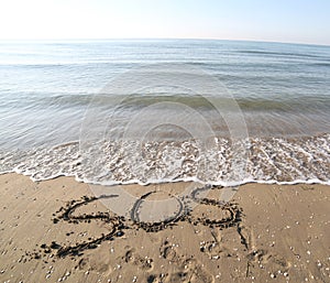 Big text SOS on the sand of the beach