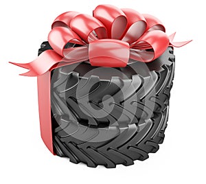 Big tire with red bow and ribbons. Heavy equipment vehicle