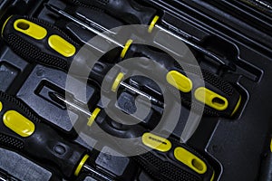 Big tool kit of black and yellow colors for the house in a box. Flat-nose pliers, screw-drivers, stationery knife and nippers.