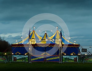 A big top of a circus lightened in the evening