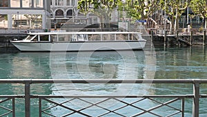 Big touristic boat moving on Rhone river with reflections on its windows