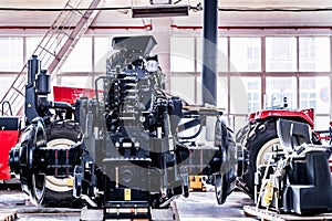 Big tractor wheels installation at assembly room at industrial plant