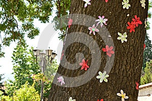 Big tree lined with colorful paper flowers