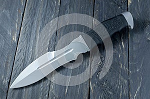 Big troops knife. Big military knife. Knife on black wood background.