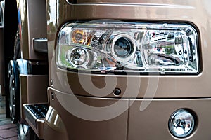 A big truck on the road. Modern new halogen headlights on a truck. Truck headlights. Square red headlight and reflector on the