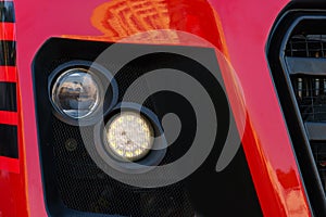 A big truck on the road. Modern new halogen headlights on a truck. Truck headlights. Square red headlight and reflector on the