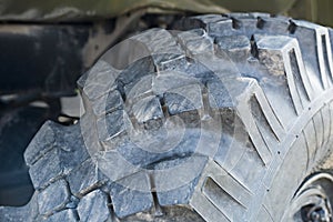 Big truck wheel a black tires closeup. Wide tires with deep protector for off road cars and trucks