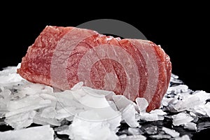 Big tuna steak on ice.