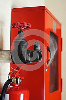 Big vintage Hydrant Valves install next to red Fire hose cabinet with part of Fire extinguisher