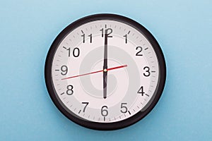 Big wall clock isolated on blue background. Six o`clock.