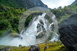 Big waterfall with stones and green land photo