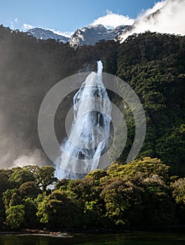 Big waterfall through forest and mountain