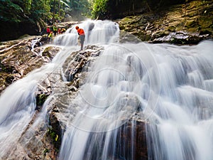 Big waterfall in the green tropical forest, white water string