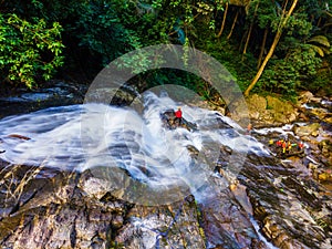 Big waterfall in the green tropical forest, white water string