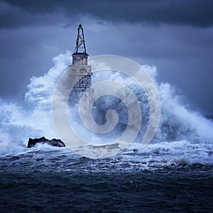 Big wave against old Lighthouse in the port of Ahtopol, Black Sea, Bulgaria on a moody stormy day