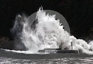 Big wave breaking on breakwater on Plentzia