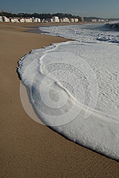 A big wave crashes on the beach