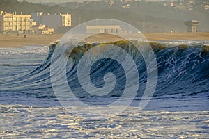 A big wave crashes on the beach