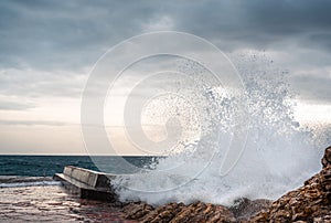 Big wave splash on pier. sea wave breaking on pier. Waves crashing on breakwaters. Waves and a storm at sea