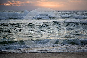 Big waves beat the shore on sunset