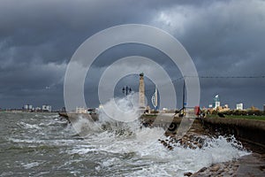 Big waves breaking over the sea defenses in southsea, UK with spinnaker tower in the background