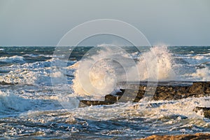 Big waves crash against coastal cliffs. Sea storm