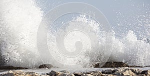 Big waves crash onto the shore with marine foam